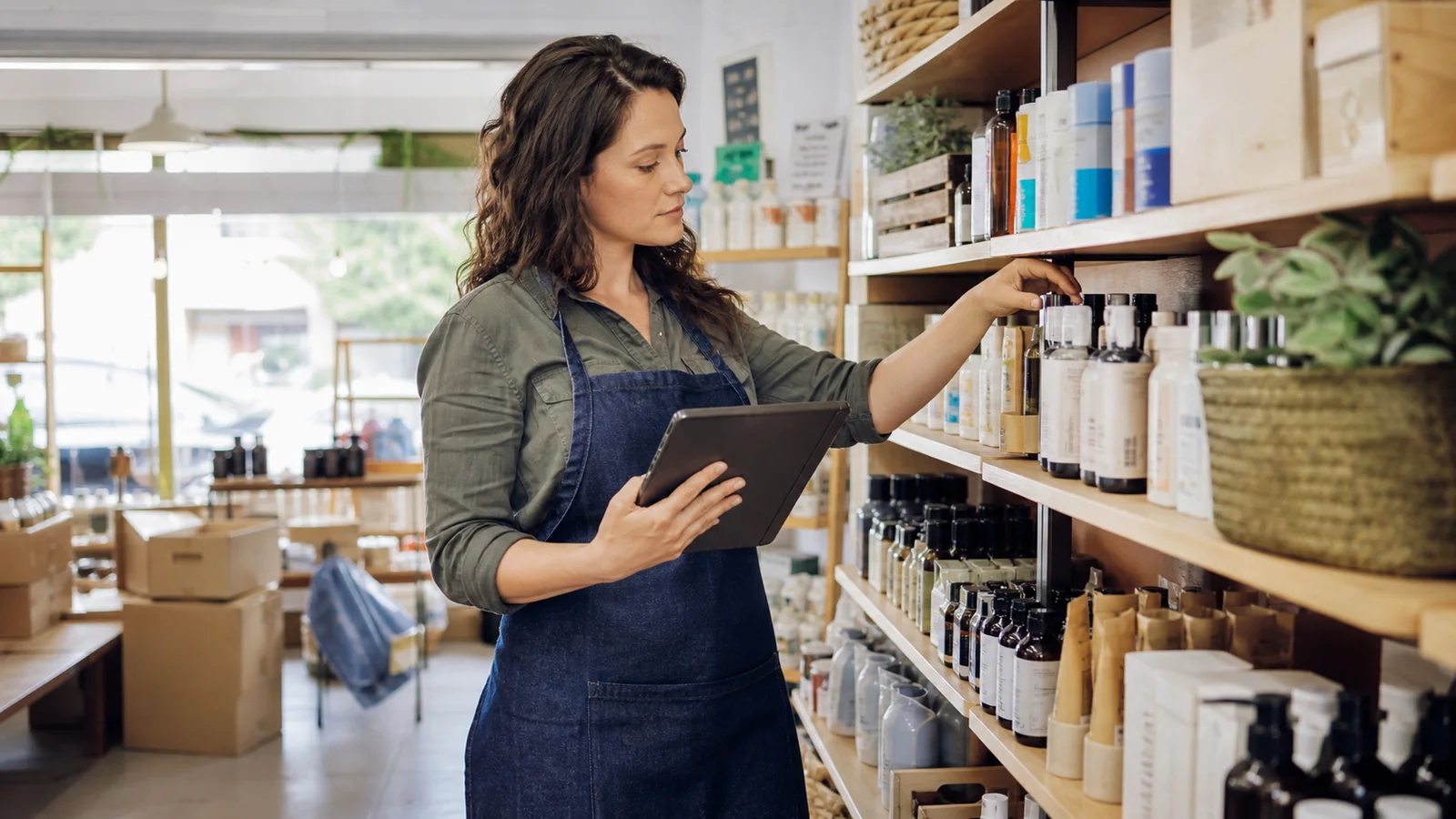 Local retail manager checking shelf stock with a tablet for AI-assisted inventory planning