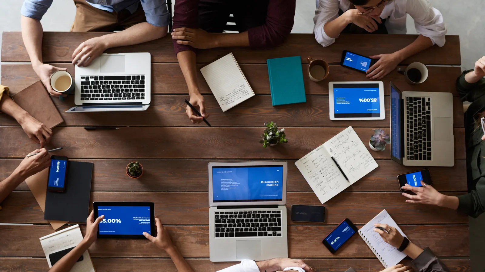 Small business team comparing AI tools, costs, and workflow requirements around a conference table